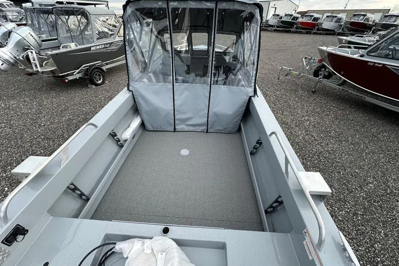 Slide: The Image of 2026 Hewescraft 200 Sportsman boat interior with protective cover, parked outdoors. - 5