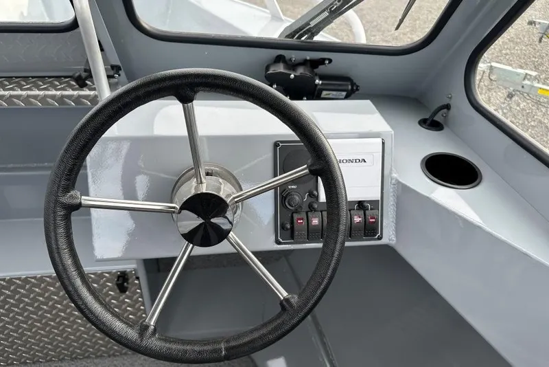 Slide: The Image of Steering wheel and controls of 2026 Hewescraft 200 Sportsman boat interior. - 7