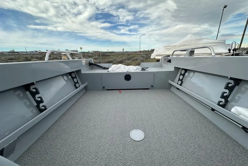 Slide: The Image of 2026 Hewescraft 200 Sportsman boat interior with spacious deck and railing under cloudy sky. - 9