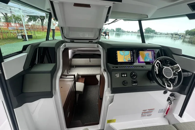 Slide: The Image of 2027 Axopar 38 Cross Cabin interior with navigation screens and steering wheel. - 15