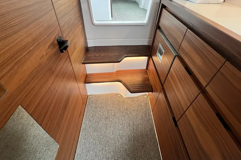 Slide: The Image of Interior of 2027 Axopar 38 Cross Cabin with wooden cabinetry and carpeted flooring. - 22
