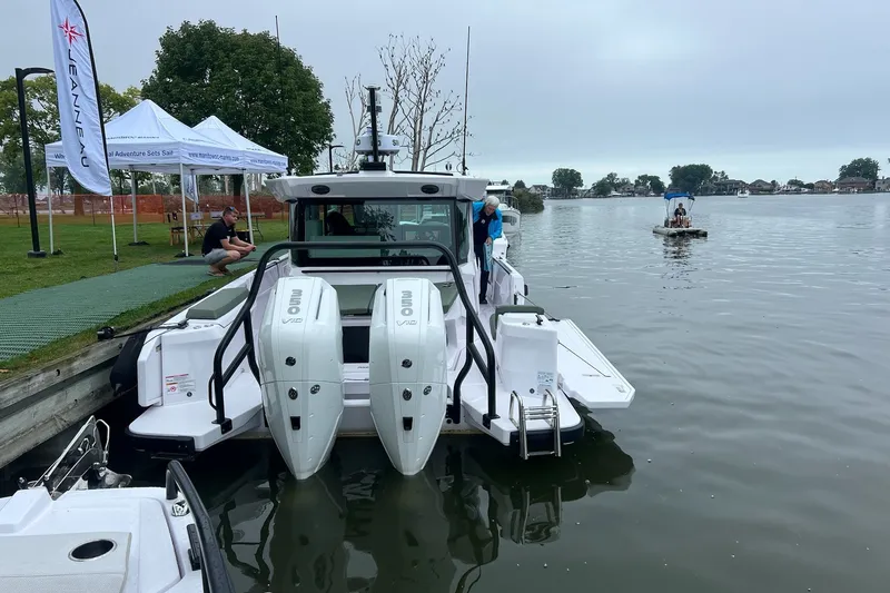 Slide: The Image of 2027 Axopar 38 Cross Cabin docked by a lakeside with people nearby. - 49