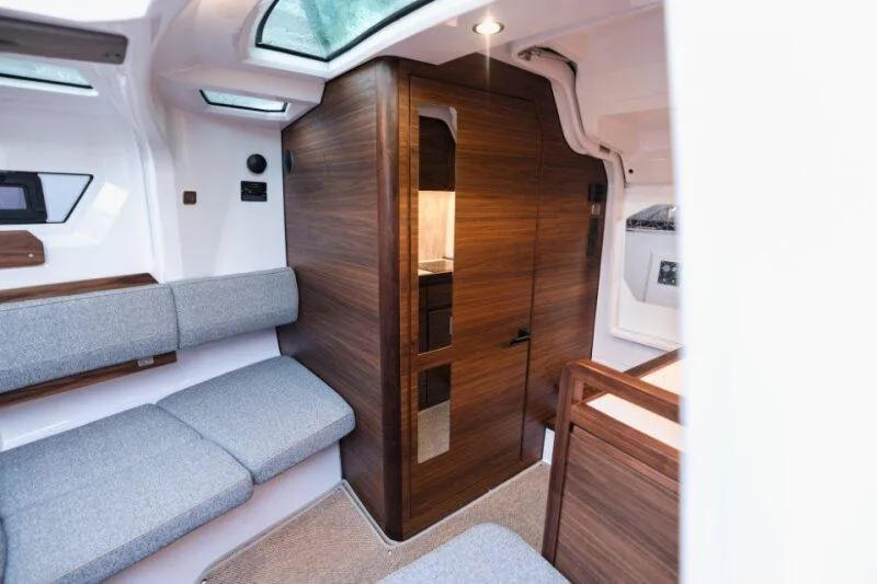 Slide: The Image of Interior of 2026 Axopar 38 Cross Cabin, featuring modern wood paneling and gray seating. - 24