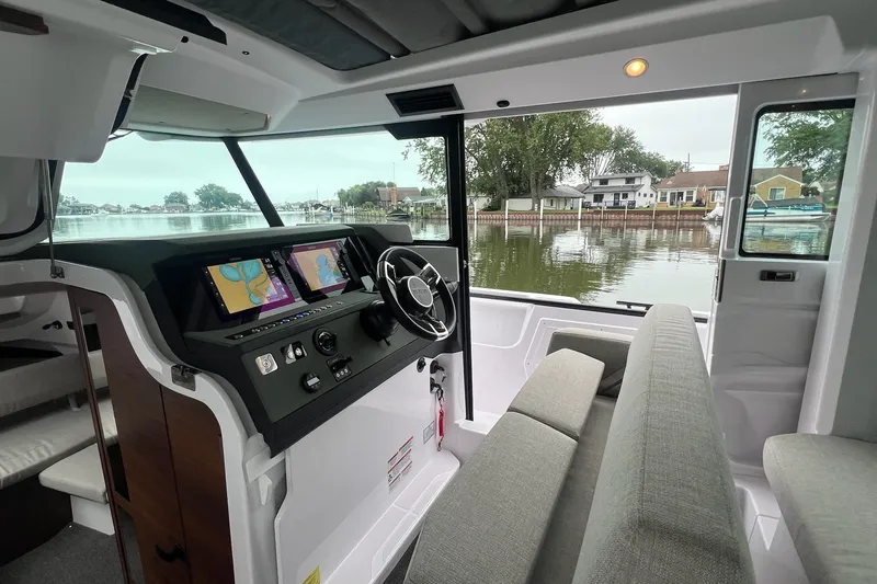 Slide: The Image of Interior of 2027 Axopar 38 Cross Cabin with modern dashboard and waterfront view. - 14