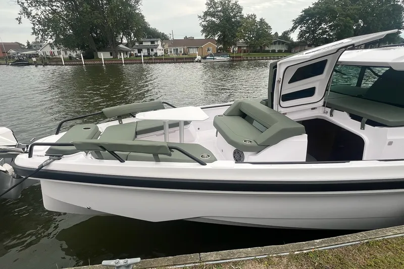 Slide: The Image of 2027 Axopar 38 Cross Cabin boat docked by a serene waterfront. - 6