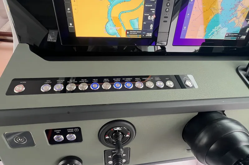 Slide: The Image of Control panel of 2027 Axopar 38 Cross Cabin with navigation screens and switches. - 18
