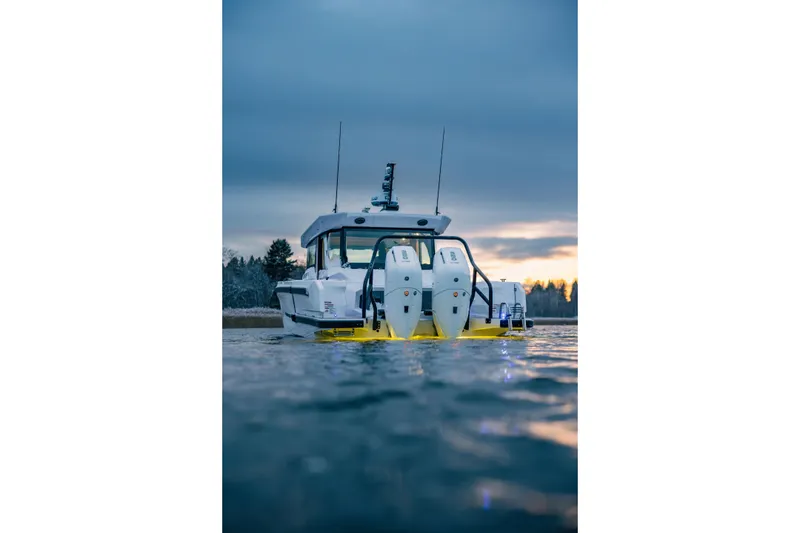 Slide: The Image of 2026 Axopar 38 Cross Cabin boat on water at sunset, rear view. - 5