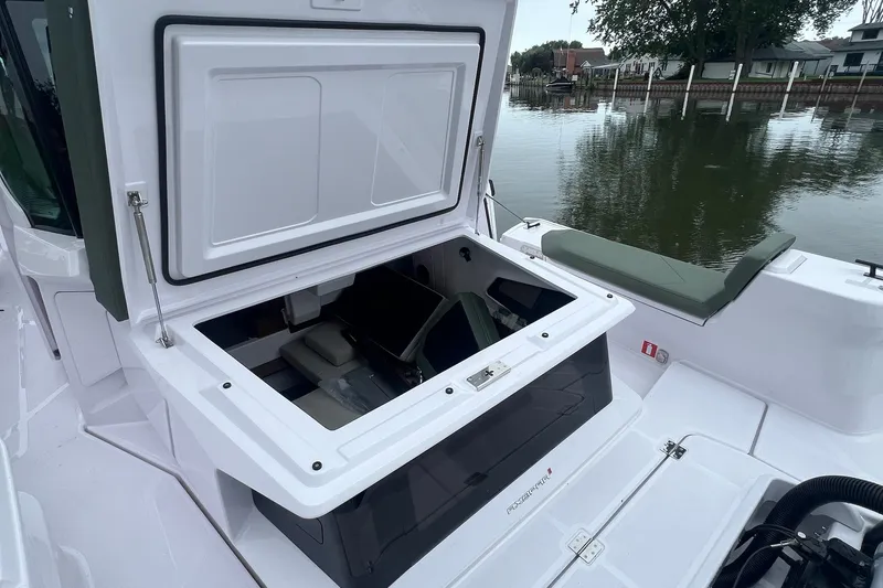 Slide: The Image of 2027 Axopar 38 Cross Cabin boat with open storage compartment by the water. - 47