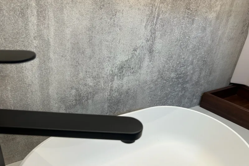 Slide: The Image of Modern bathroom sink with sleek black faucet and textured gray wall background. - 32