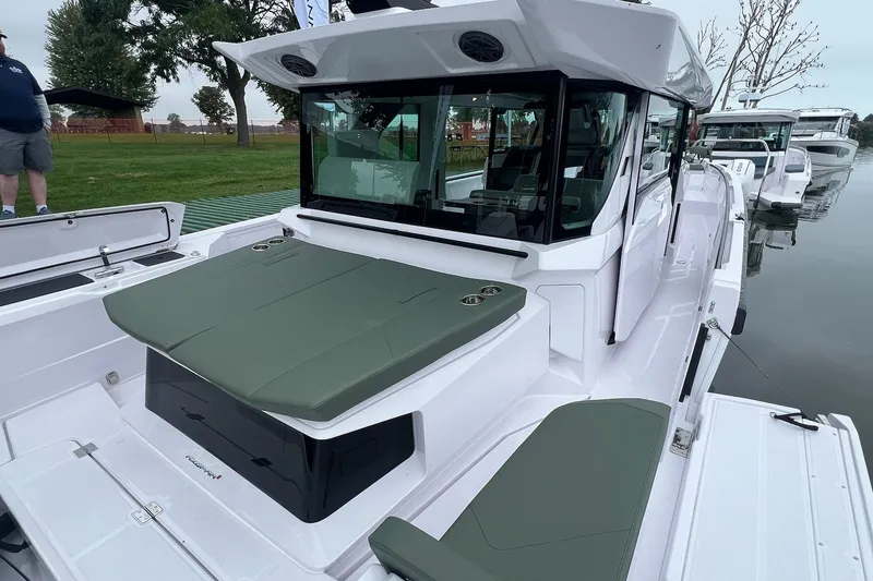 Slide: The Image of 2027 Axopar 38 Cross Cabin boat with sleek design and green seating, docked by the water. - 41
