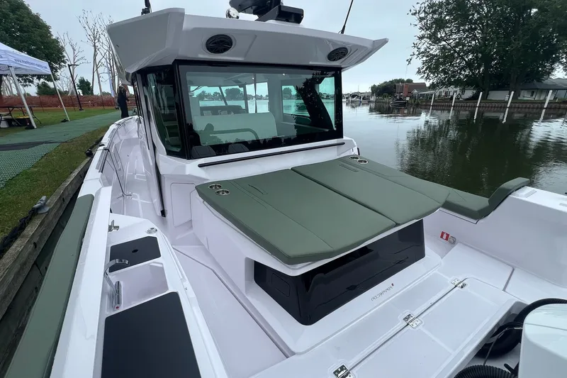 Slide: The Image of 2027 Axopar 38 Cross Cabin boat docked by a serene waterfront. - 45
