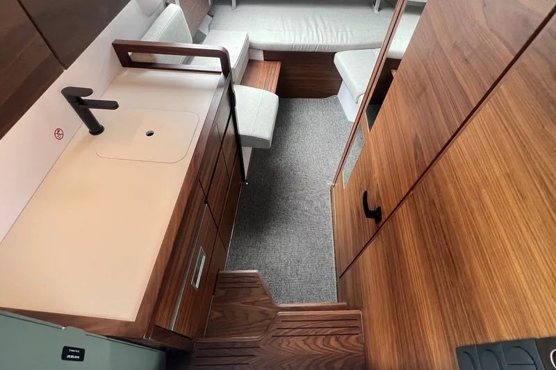 Slide: The Image of Interior of 2027 Axopar 38 Cross Cabin with modern wood finish and compact kitchenette. - 20