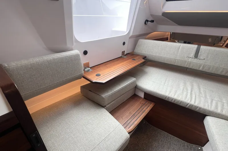 Slide: The Image of Interior of 2027 Axopar 38 Cross Cabin with modern seating and wooden table. - 24