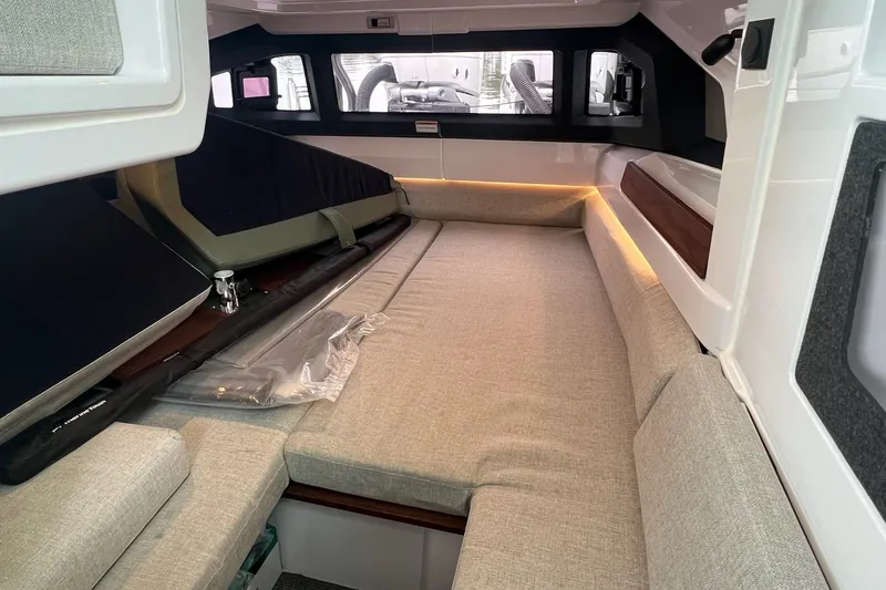 Slide: The Image of 2027 Axopar 38 Cross Cabin interior with beige seating and ambient lighting. - 9