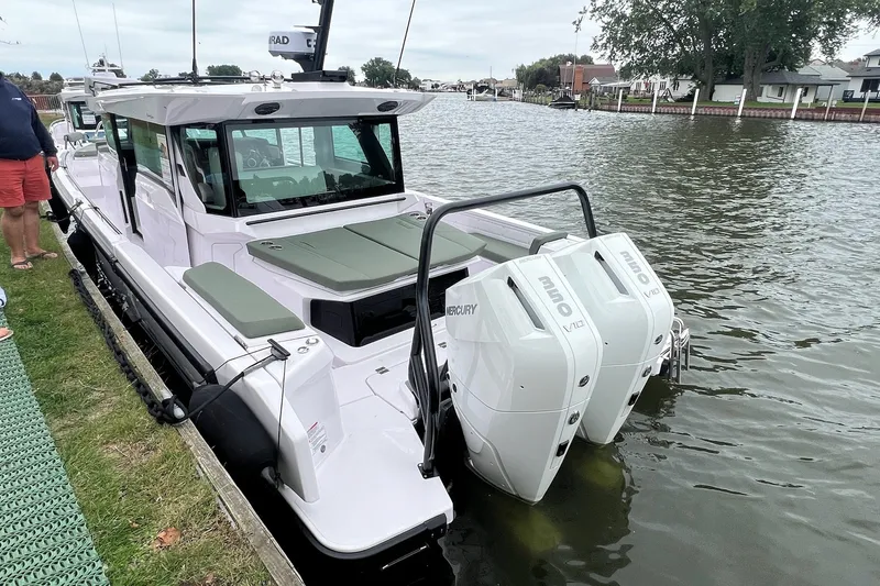 Slide: The Image of 2027 Axopar 38 Cross Cabin boat docked with twin Mercury engines. - 5