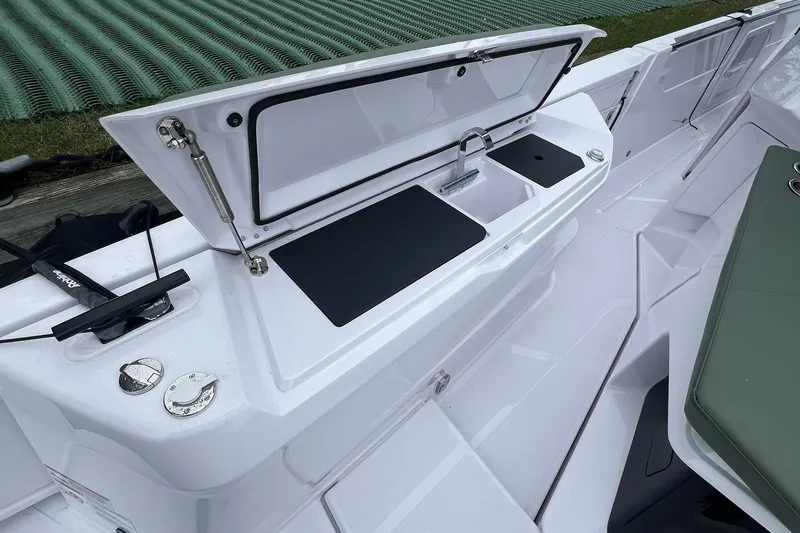 Slide: The Image of 2027 Axopar 38 Cross Cabin boat with open storage compartment and sink. - 44