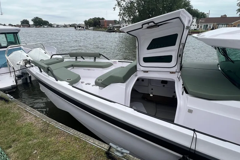 Slide: The Image of 2027 Axopar 38 Cross Cabin boat docked by the water, featuring open storage and seating. - 3