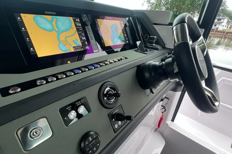 Slide: The Image of 2027 Axopar 38 Cross Cabin dashboard with navigation screens and steering wheel. - 17