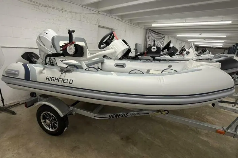 The Image of 2026 Highfield Classic 310 inflatable boat on Genesis trailer in showroom. - 1