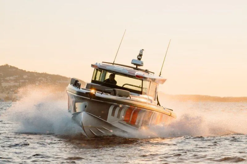 The Image of 2026 Axopar 38 Cross Cabin boat navigating through waves at sunset. - 0