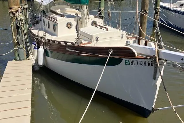 Slide: The Image of 1982 Falmouth Cutter 22 sailboat docked in marina, featuring classic design and wooden accents. - 18