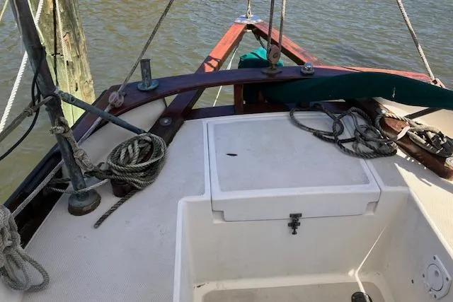 Slide: The Image of 1982 Falmouth Cutter 22 sailboat deck with ropes and wooden trim. - 21