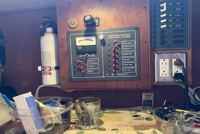 Slide: The Image of Control panel inside a 1982 Falmouth Cutter 22 boat, featuring switches and a fire extinguisher. - 23