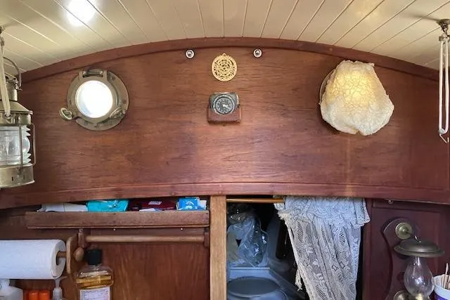 Slide: The Image of Interior of 1982 Falmouth Cutter 22 sailboat with wooden paneling and nautical decor. - 24