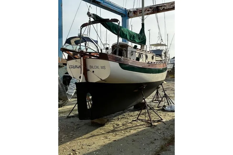 Slide: The Image of 1982 Falmouth Cutter 22 sailboat on stands, Biloxi, MS, with green sail cover. - 5