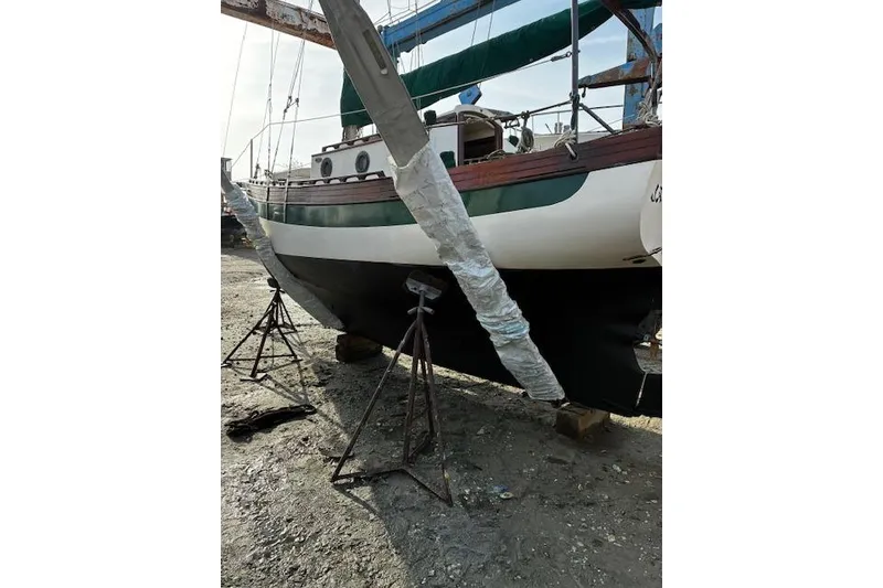 Slide: The Image of 1982 Falmouth Cutter 22 sailboat on stands, undergoing maintenance. - 8