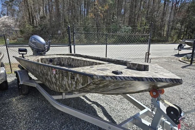 Slide: The Image of 2025 Avid 16 Commander boat with camouflage design on a trailer, parked outdoors. - 3
