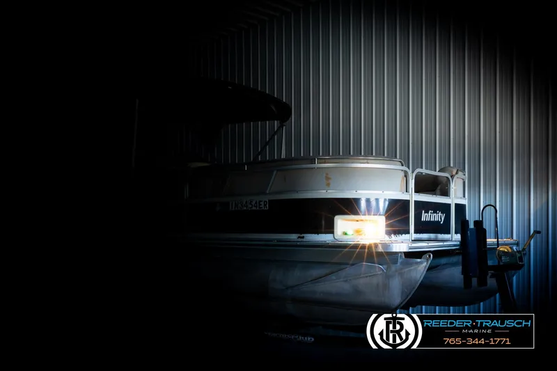 Slide: The Image of 2004 Smoker Craft 820 Infinity Cruise boat in dimly lit storage, front view. - 4