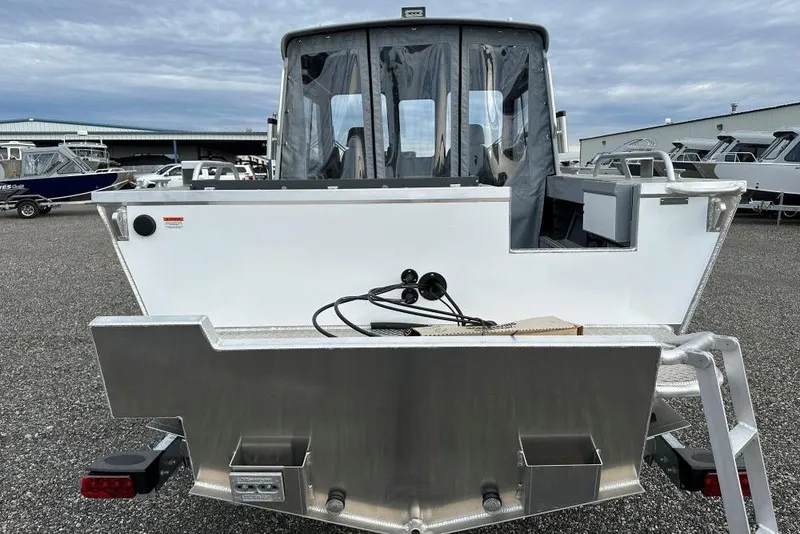 Slide: The Image of 2026 Hewescraft 190 Sea Runner Hardtop boat, rear view, in a marina setting. - 4