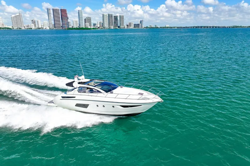 The Image of 2014 Azimut Atlantis 48 yacht cruising on turquoise waters near a city skyline. - 1