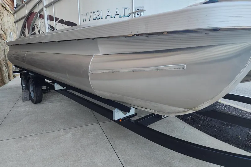 Slide: The Image of 2018 Bennington SX22 pontoon boat on trailer, side view showing hull details. - 10