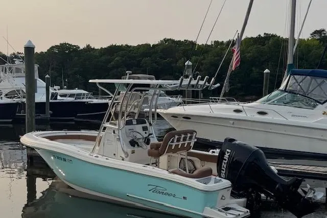 The Image of 2021 Pioneer 222 Islander boat docked, featuring a Suzuki outboard motor. - 0