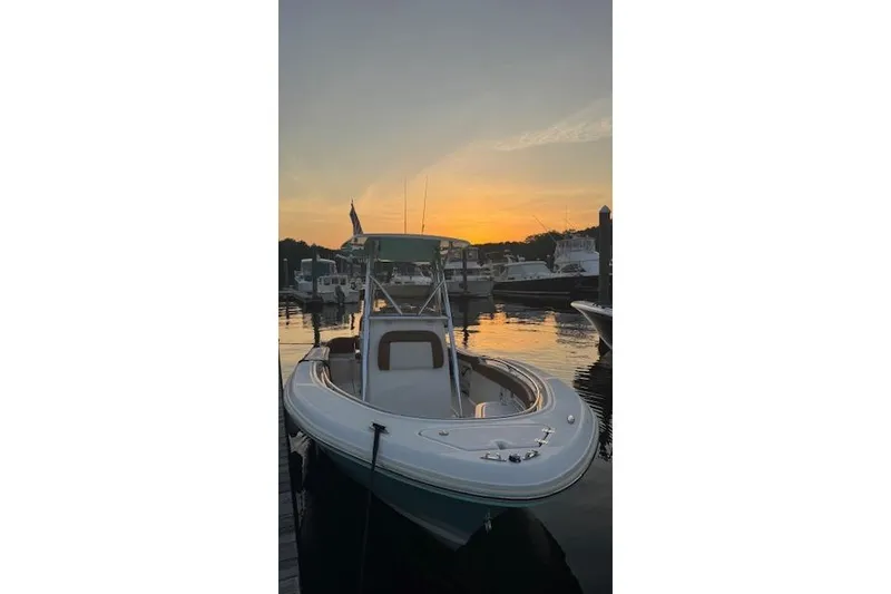 Slide: The Image of 2021 Pioneer 222 Islander boat docked at sunset, reflecting on calm water. - 10