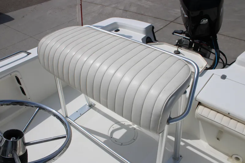 Slide: The Image of 2008 Mako 2201 Tunnel Inshore boat with white cushioned seating and steering wheel. - 15