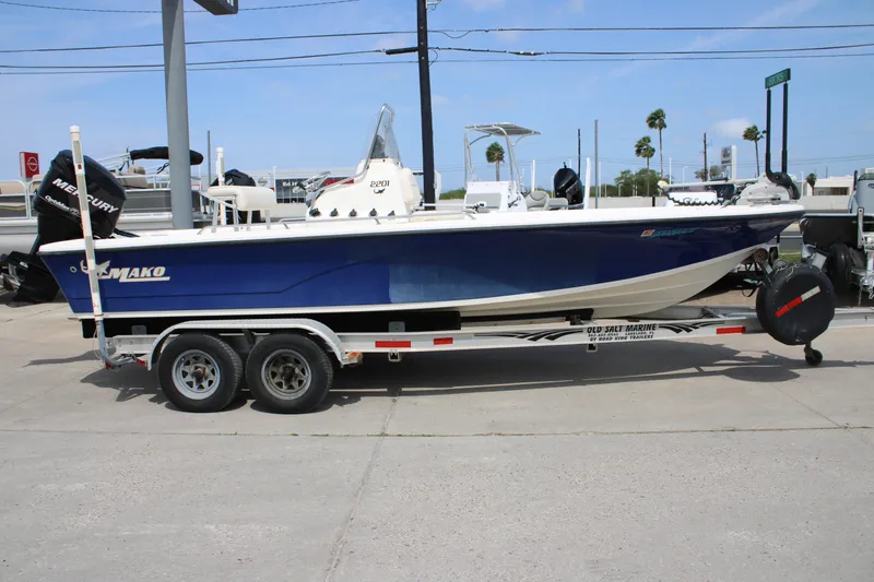 Slide: The Image of 2008 Mako 2201 Tunnel Inshore boat on trailer, blue hull, parked outdoors. - 2