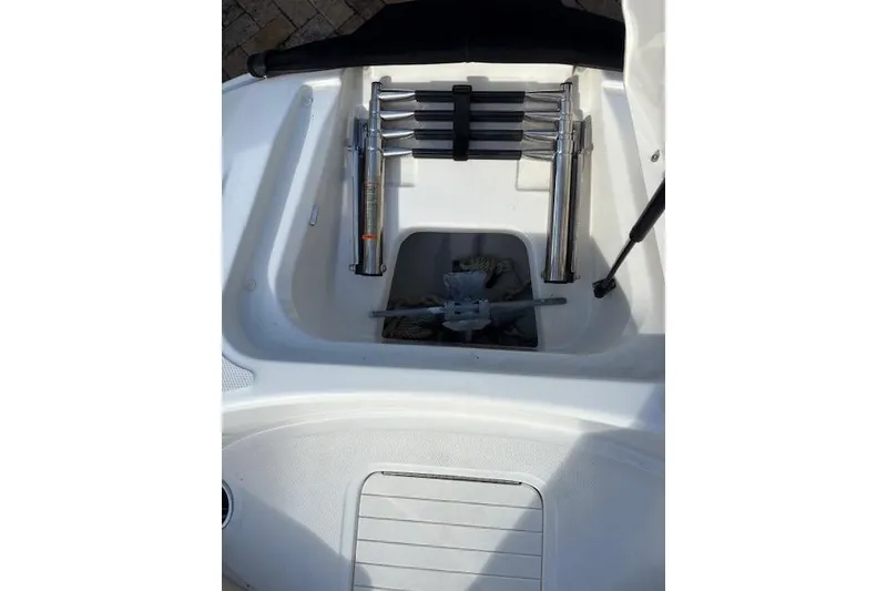 Slide: The Image of 2011 Sea Ray 220 Sundeck boat interior with beige seating and carpeted floor. - 11