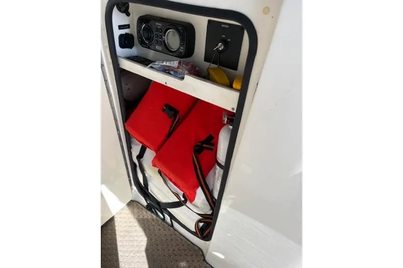 Slide: The Image of Interior of 2011 Sea Ray 220 Sundeck boat with beige seating and cup holders. - 12