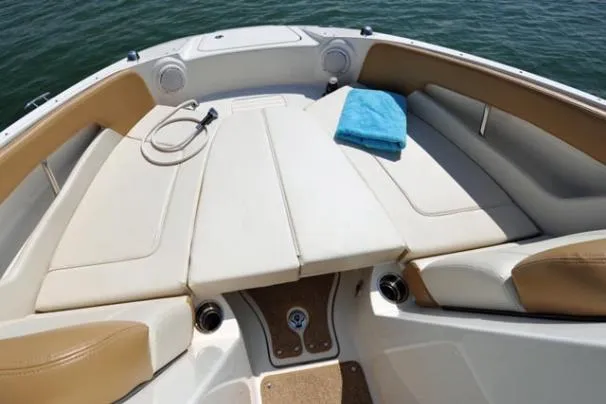 Slide: The Image of 2011 Sea Ray 220 Sundeck boat interior with cushioned seating and carpeted floor. - 2