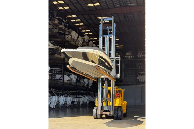 Slide: The Image of Forklift lifting a 2011 Sea Ray 220 Sundeck boat in a storage facility. - 22