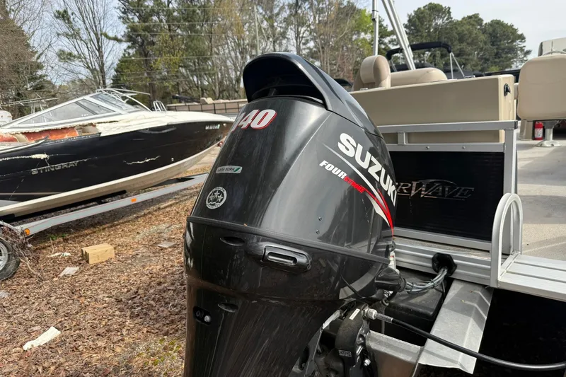 Slide: The Image of 2016 SilverWave 230 Island CC with Suzuki outboard motor in a boatyard setting. - 16