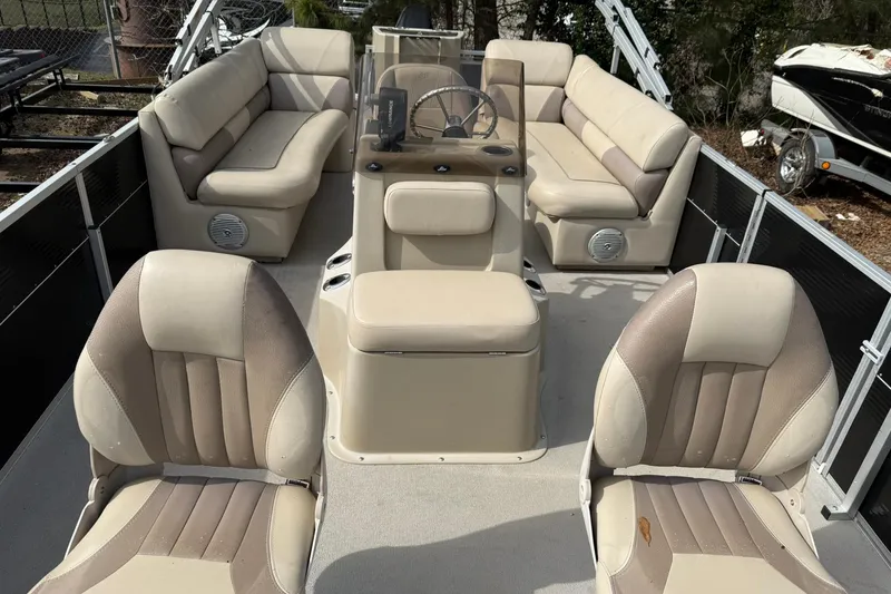 Slide: The Image of 2016 SilverWave 230 Island CC boat interior with beige seating and steering console. - 3