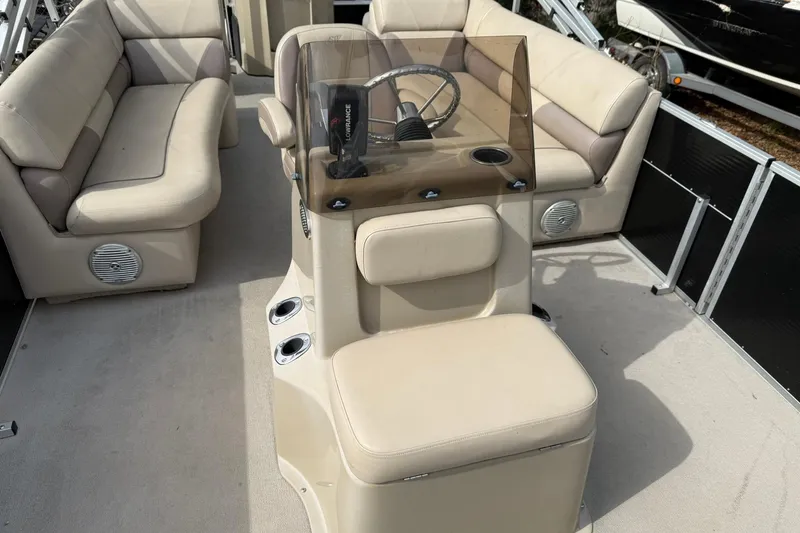 Slide: The Image of 2016 SilverWave 230 Island CC boat interior with beige seating and steering console. - 4
