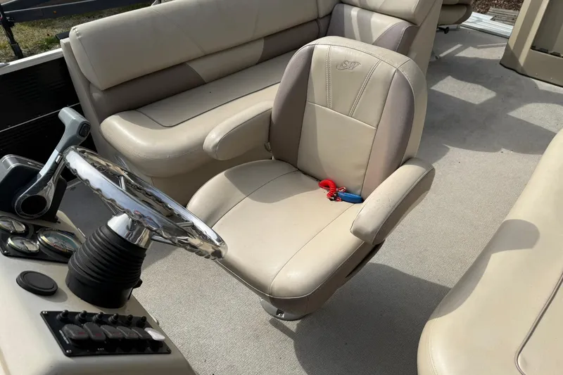 Slide: The Image of 2016 SilverWave 230 Island CC boat interior with beige seating and steering wheel. - 8