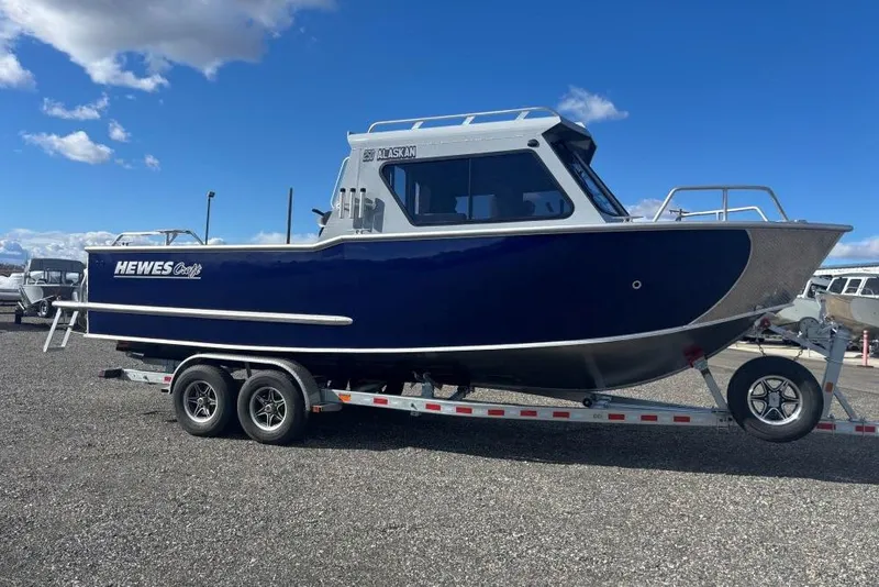 The Image of 2026 Hewescraft 250 Alaskan boat on trailer under blue sky. - 1