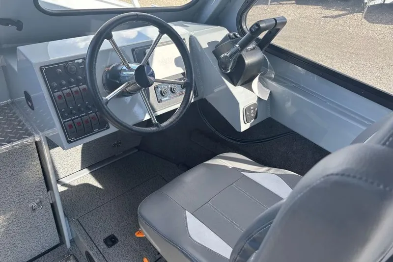 Slide: The Image of 2026 Hewescraft 250 Alaskan boat interior with steering wheel and control panel. - 6