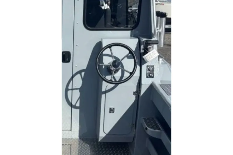 Slide: The Image of Steering wheel of 2026 Hewescraft 250 Alaskan boat, showcasing control panel. - 9